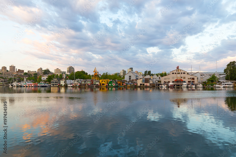 Naklejka premium City landscape with buildings, yachts, and floating houses along the shore. Sunrise at False Creek waterfront, Vancouver, British Columbia, Canada.