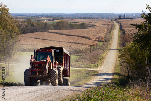 Rural landscape with tractor on the foreground and corn fields and rolling hills on the background