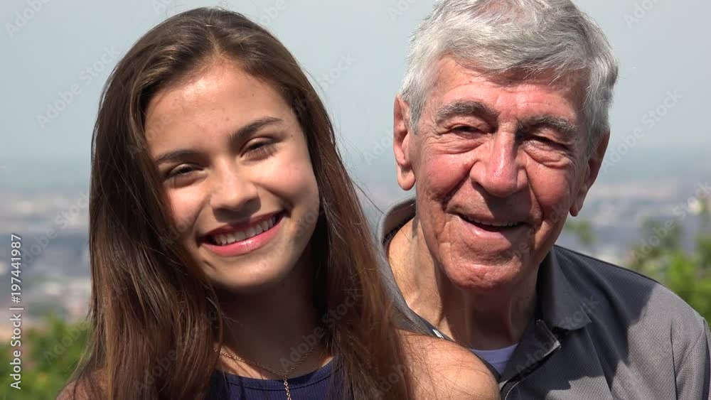 Smiling Hispanic Grandfather And Granddaughter Smiling Hispanic Grandfather And Granddaughter