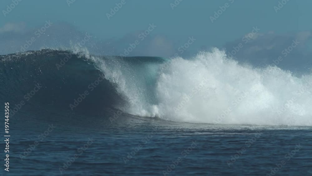 SLOW MOTION: Countless turquoise water drops fly around breaking ocean wave. Powerful swell breaks and splashes as it closes in on sunny tropical beach. Epic hollow wave slowly moves towards the coast SLOW MOTION: Countless turquoise water drops fly around breaking ocean wave. Powerful swell breaks and splashes as it closes in on sunny tropical beach. Epic hollow wave slowly moves towards the coast