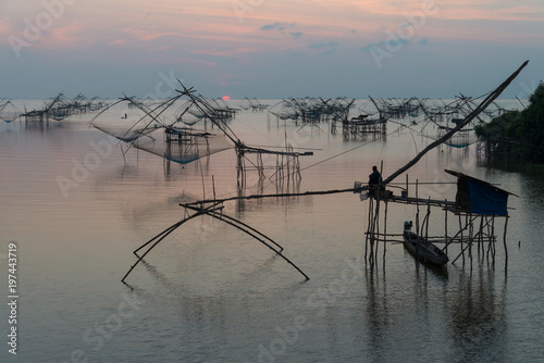 Landmark of traditional fishing net tools in the lake with beautiful morning sunrise at Pakpra village.
