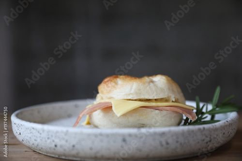 Bagel ham cheese in close up on wood background in coffee shop