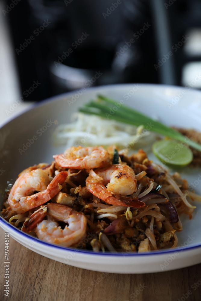 Pad thai with shrimp . Thai food on wood background