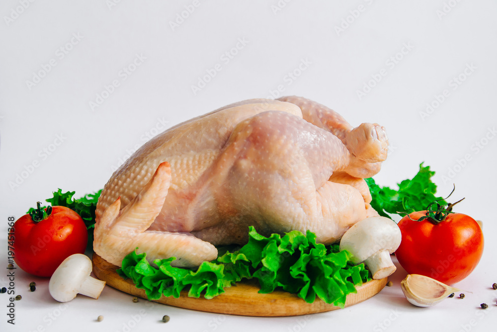 raw chicken on the cutting board, with tomatoes, garlic, mushrooms and seasonings on lettuce leaves, isolated on white background, side view raw chicken on the cutting board, with tomatoes, garlic, mushrooms and seasonings on lettuce leaves, isolated on white background, side view
