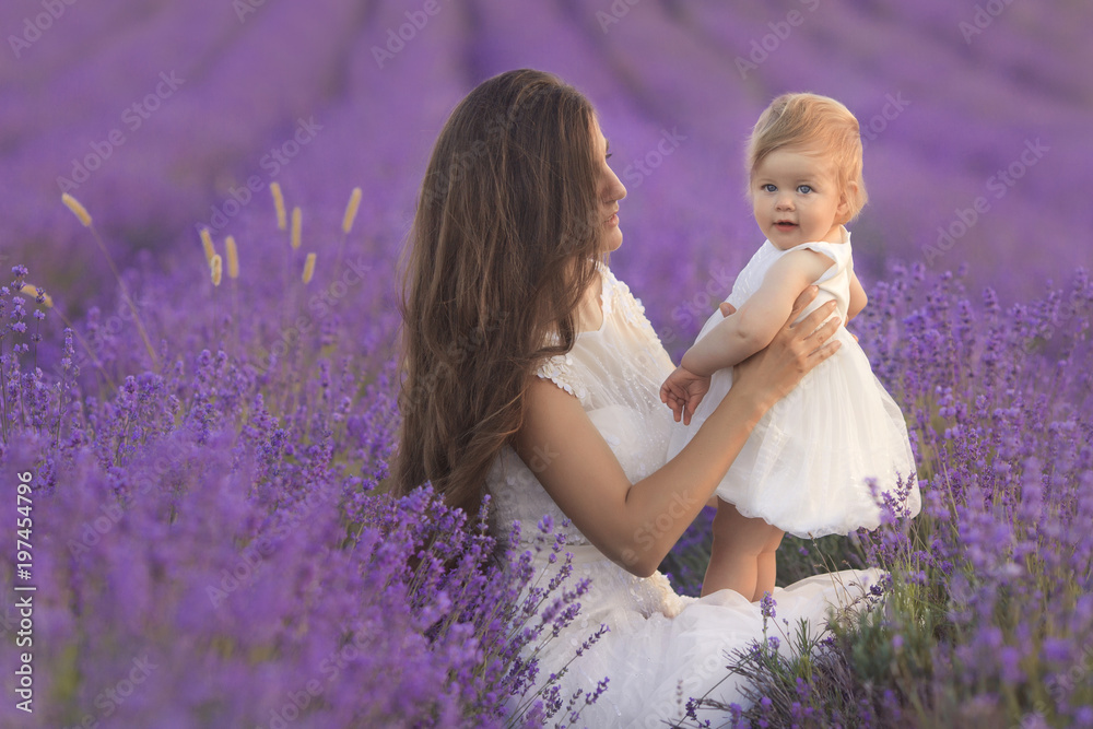 Happy beautiful mother and cute little daughter have fun in aroma lavender fields. Family holiday in summer day. Happy beautiful mother and cute little daughter have fun in aroma lavender fields. Family holiday in summer day.