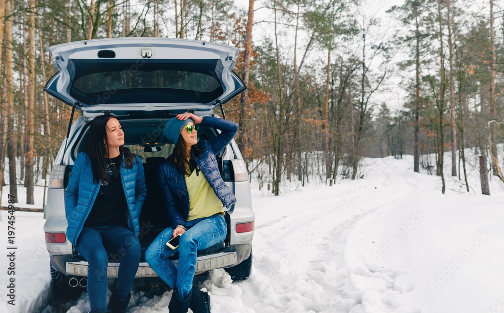 Two young women traveler traveling by car winter Travel background