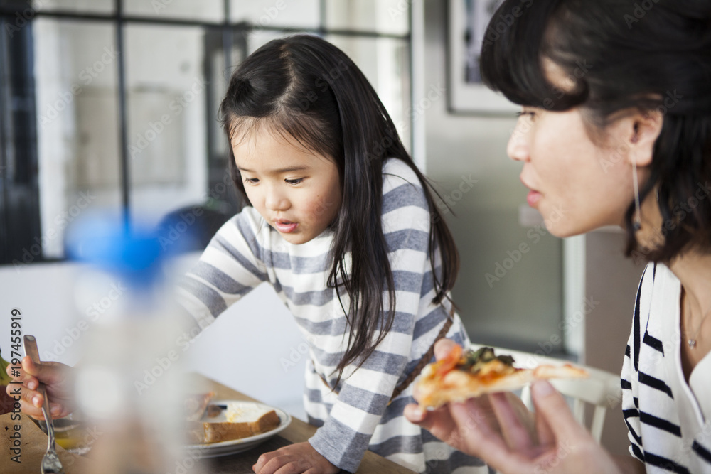 ピザを食べているお母さんと女の子。 ピザを食べているお母さんと女の子。