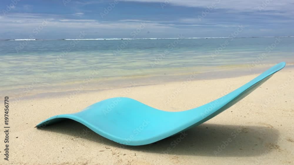 An empty blue chair on a tropical sandy beach in the Cook Islands. Travel, holiday and vacation concept. Copy space An empty blue chair on a tropical sandy beach in the Cook Islands. Travel, holiday and vacation concept. Copy space