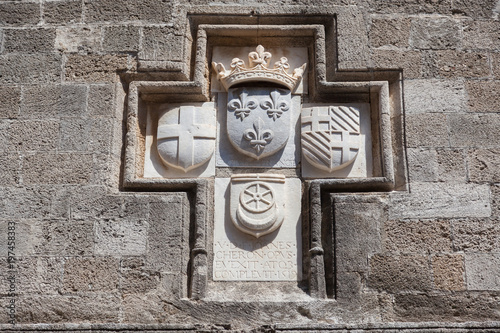 Knightly coat of arms on the wall of a house of Ippoton street in Rhodes island, Greece photo