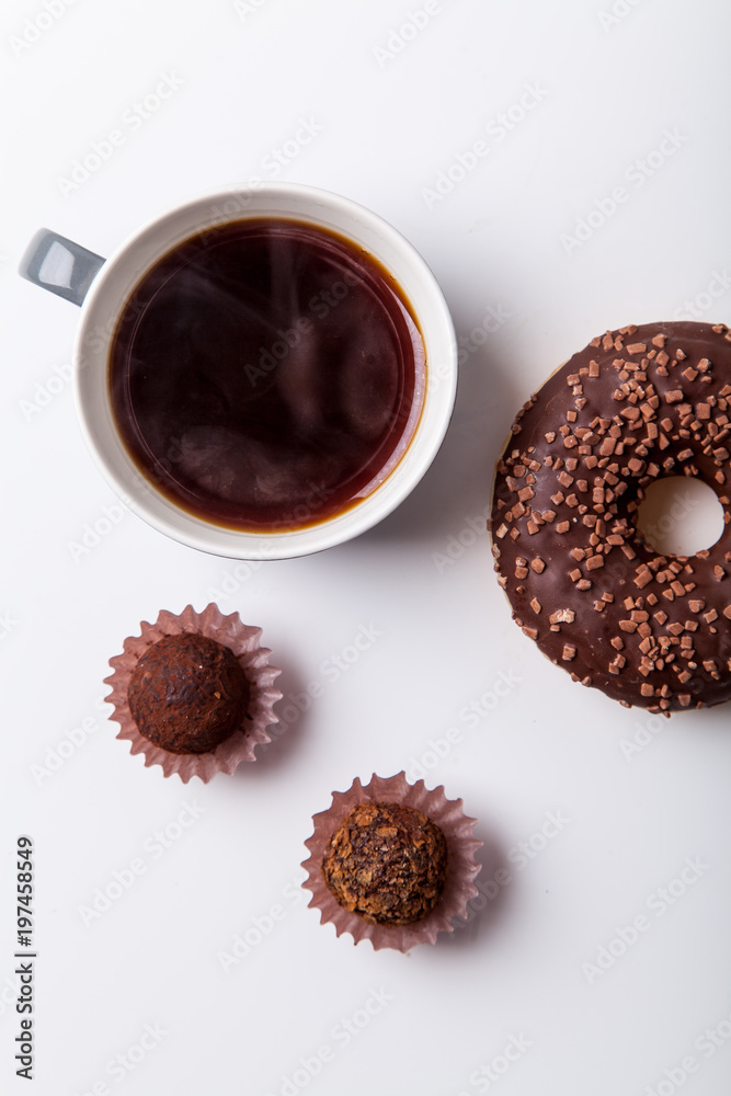 Chocolate donuts with cup of black coffee and sun glasses on brown background. Monochromatic concept. Chocolate donuts with cup of black coffee and sun glasses on brown background. Monochromatic concept.