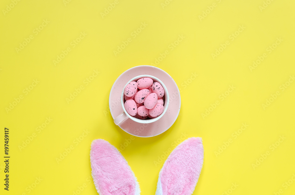 Easter holiday background with bunny ears and easter eggs in coffee cup Easter holiday background with bunny ears and easter eggs in coffee cup