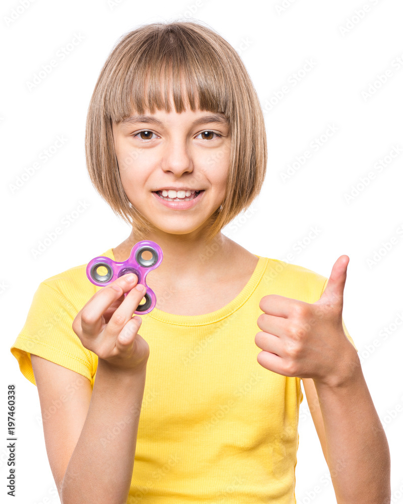 Young girl holding popular fidget spinner toy close up portrait. Happy smiling child playing with Spinner and making thumb gesture, isolated on white background. Stock Photo | Adobe Stock
