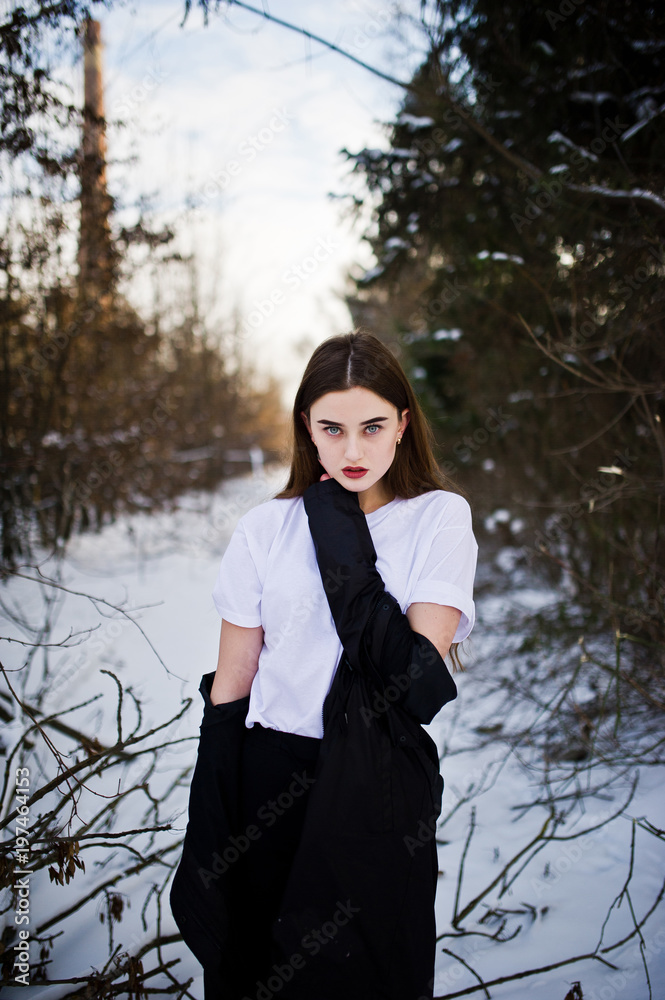 Fashionable long legs brunette model in long black cloak posed outdoor at winter day. Fashionable long legs brunette model in long black cloak posed outdoor at winter day.