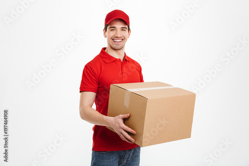 Slika na platnu Happy young delivery man with parcel post box