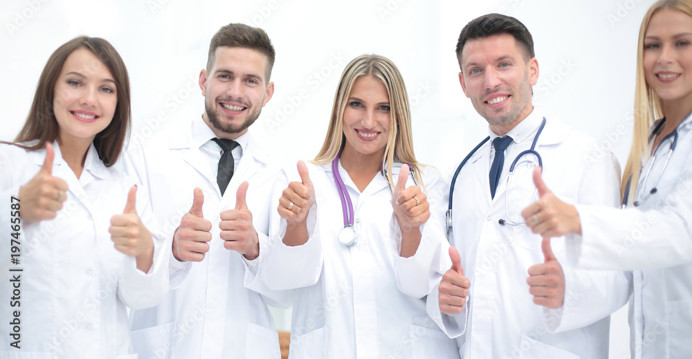 Portrait of a doctor and medical team showing thumb up