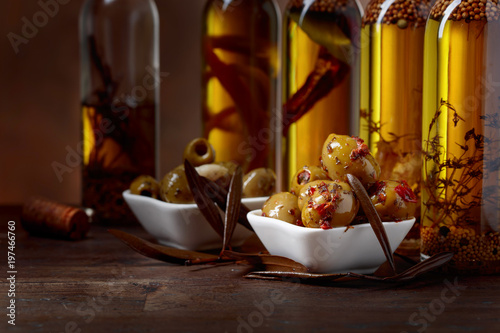 Spiced green olives and bottles with olive oil .