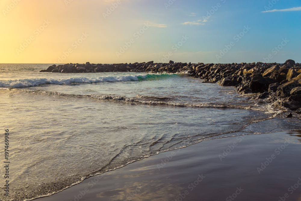 The blue waters of the Atlantic Ocean flowing into rocky cove off the coast of Tenerife.rocky coast of Canary Islands. The blue waters of the Atlantic Ocean flowing into rocky cove off the coast of Tenerife.rocky coast of Canary Islands.