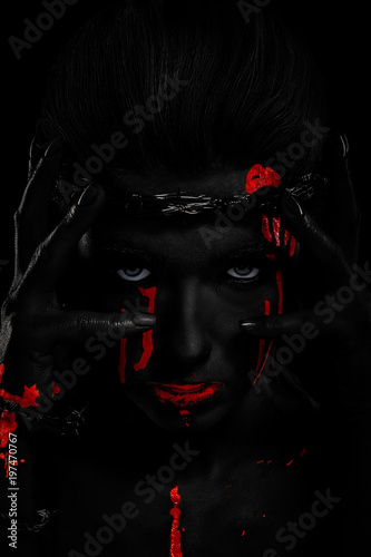 Black skin effect. girl with a bloody face, with white skin and a wreath on her head. barbed wire