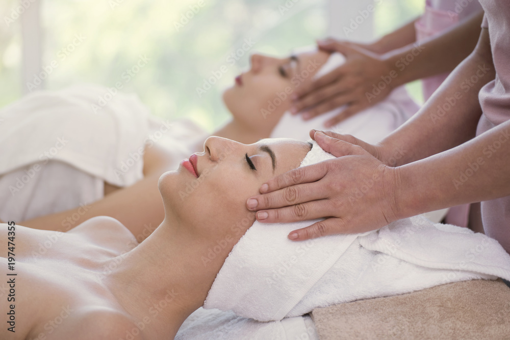 Masseur doing massage the head of beautiful young woman relaxing in the spa salon. Masseur doing massage the head of beautiful young woman relaxing in the spa salon.