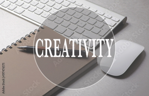 Creativity concept with the word written on keyboard, notebook, pen and mouse. Conceptual. photo