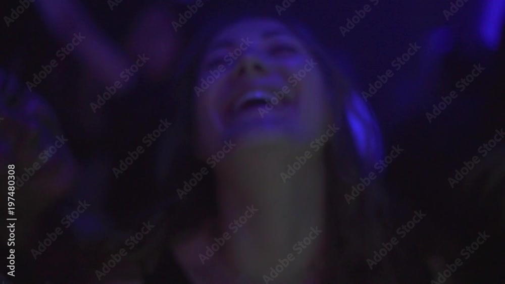 Young blonde Woman laughs with friends on night out to the club. Slow motion shot with lights flashing Young blonde Woman laughs with friends on night out to the club. Slow motion shot with lights flashing
