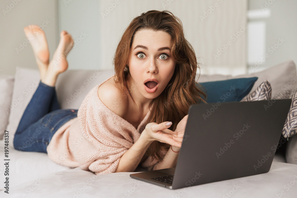 Fototapeta premium Portrait of a confused young woman using laptop computer