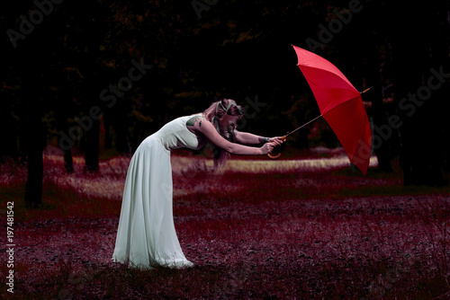 Mary Poppins, modern fashion concept. Caucasian white female model standing with red umbrella and gas mask. Beautiful woman with long hair, in a white dress resting in nature and enjoys weather. photo