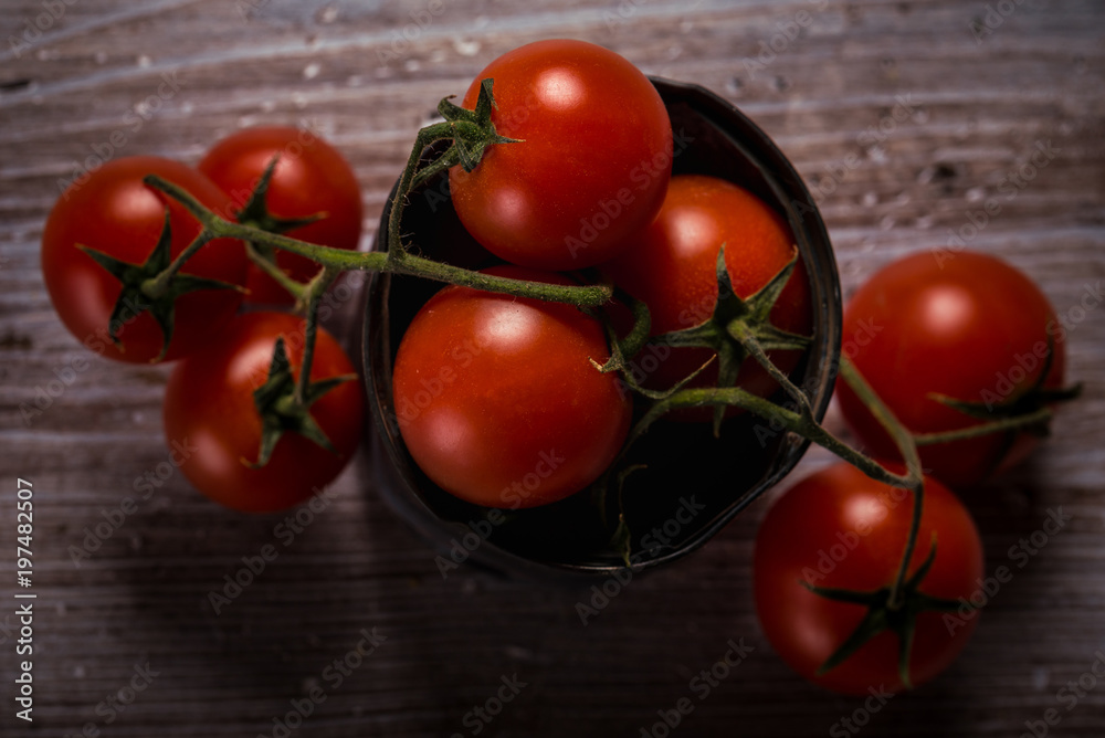 Top view on several cherry tomatoes on green twig in vintage metal can Top view on several cherry tomatoes on green twig in vintage metal can