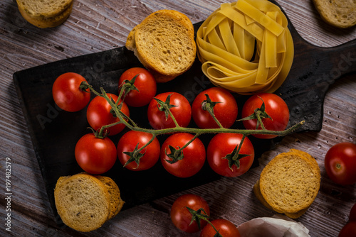 Top view on small cherry tomatoes on vintage worn chopping board photo