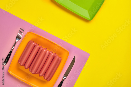 Sausages on a yellow and pink minimal background. Flat lay. Top view. photo