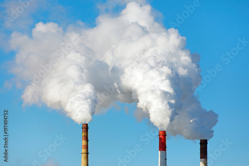 Smoking pipes of thermal power plant on blue sky background