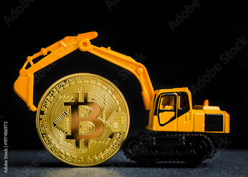 Bitcoin cryptocurrency mining concept. Blockchain technology. Miniature excavator with Bitcoin coin. With copy space.