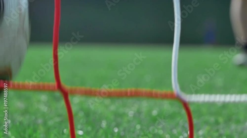 Football player scoring. Slow motion shot - soccer player scoring - ball entering the goal