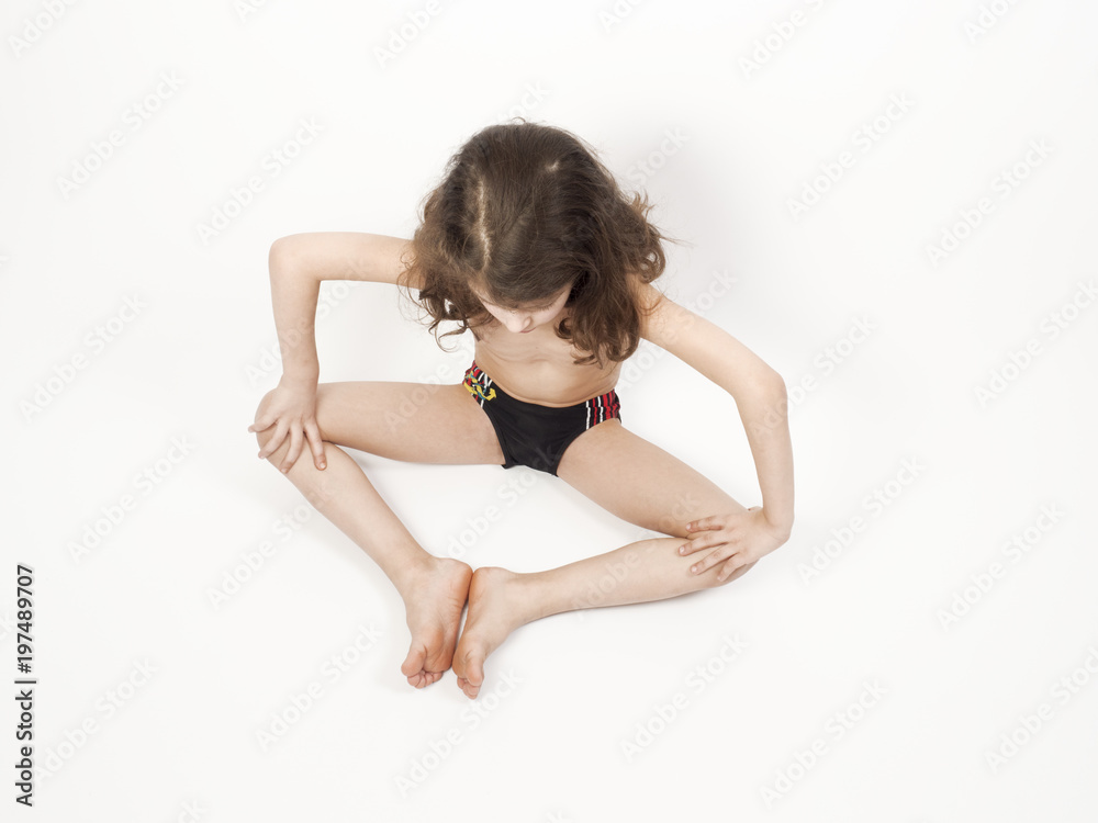 Fototapeta premium Little boy doing gymnastics on the floor