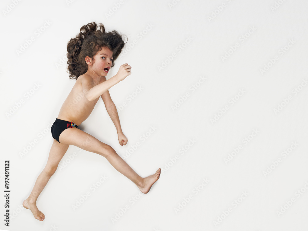 Young Caucasian boy running action on light background Young Caucasian boy running action on light background