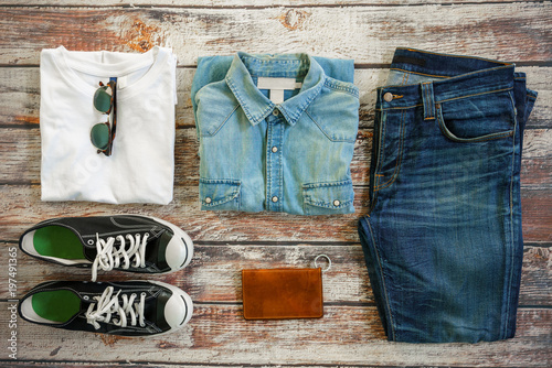 Traveler items vacation travel accessories for holiday or long weekend Simple Denim style Vintage Classic Hipster Look Clothing Overhead view choice guide idea for planning travel around the world 