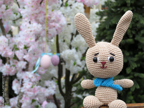 Knitted Easter Bunny on the background of festive spring decorations