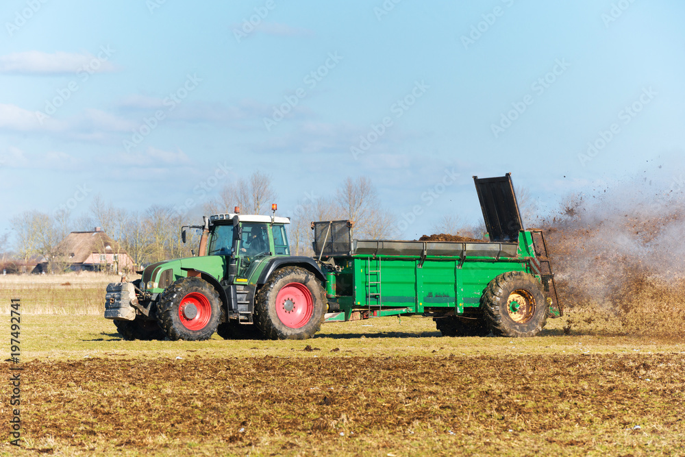Fototapeta premium Tractor with manure spreader on the field - 1303