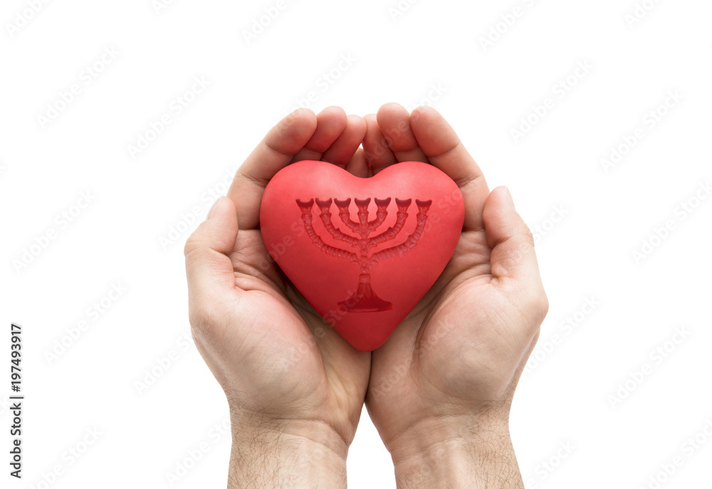 Red heart with imprinted menorah in man's hands. Red heart with imprinted menorah in man's hands.