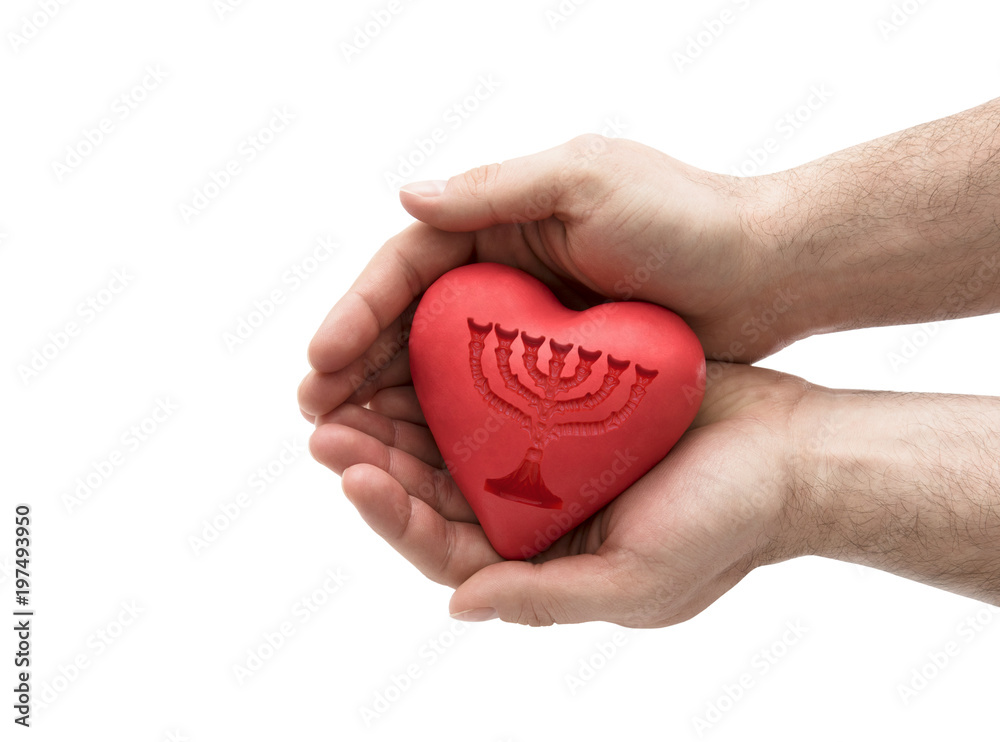 Red heart with imprinted menorah in man's hands.