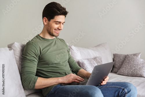 Smiling young man using laptop computer