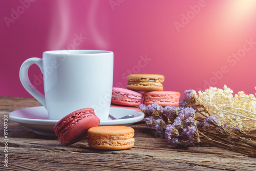 Different types color of macaroons with Cup of hot tea on Old grunge wooden background