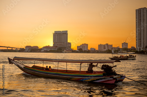 local passenger ship for tourism sailing on river with Thailand building condominium and sunset twilight sky background