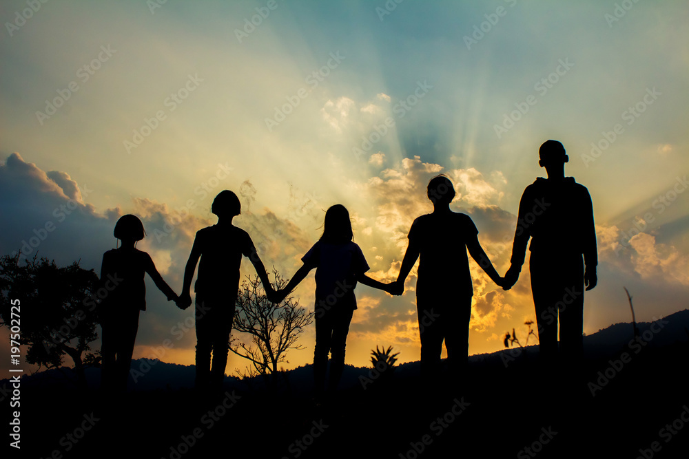 Silhouette group children playing on mountain at sunset time. Silhouette group children playing on mountain at sunset time.