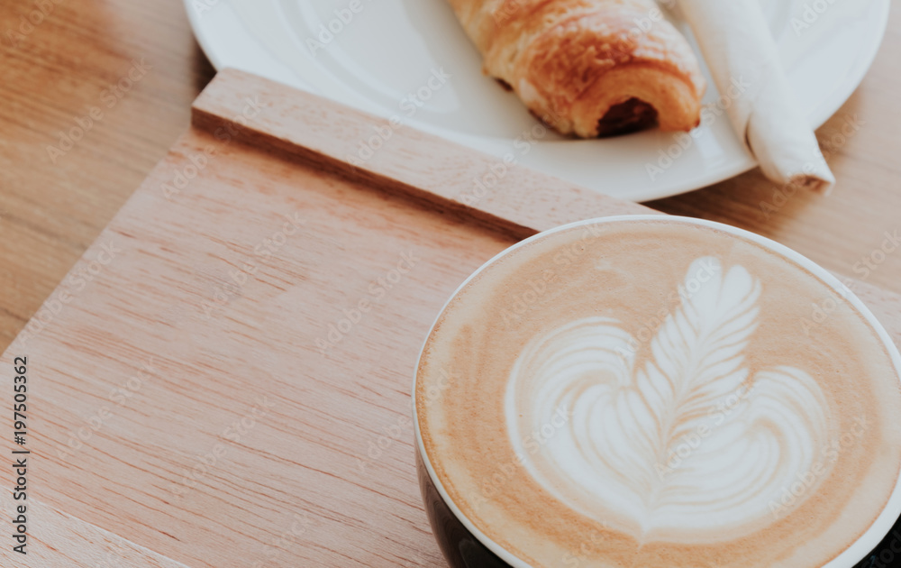 Breakfast with coffee and croissants in a wooden tray on table Breakfast with coffee and croissants in a wooden tray on table