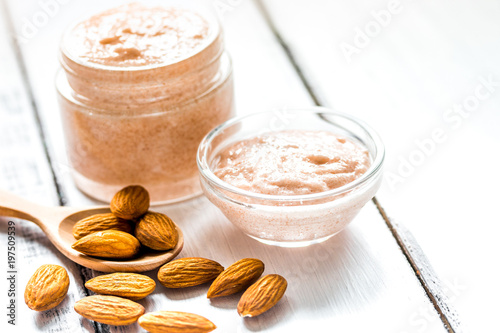 cosmetic set with almond scrub on table background