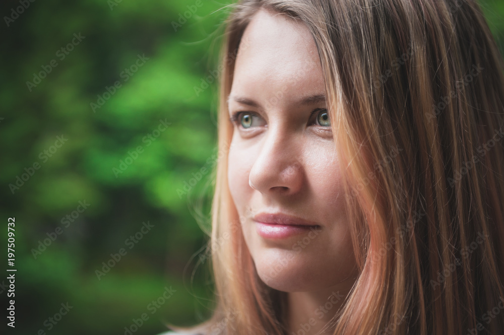 Portrait of beautiful woman on green summer background