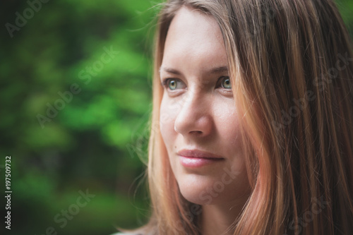 Portrait of beautiful woman on green summer background