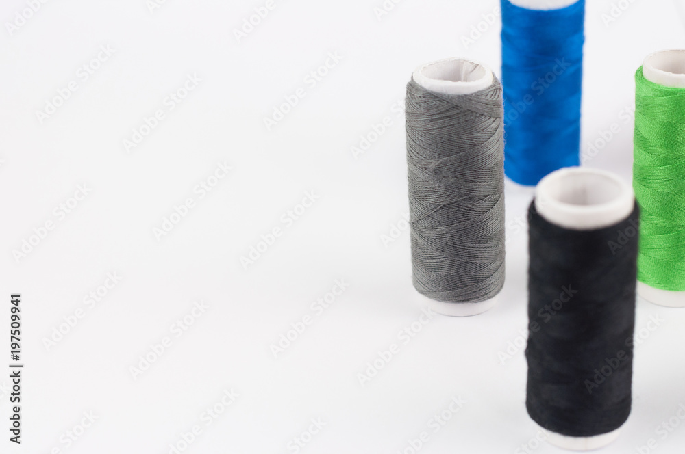 Lot of bobbins of new colorful threads on white background Lot of bobbins of new colorful threads on white background