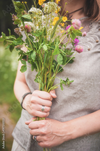 Woman hands with meadow flowers bouquet in summer